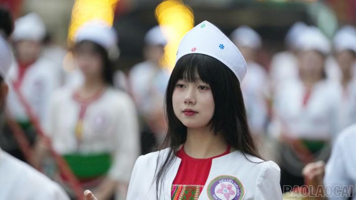 Thiếu nữ dân tộc Mường trong trang phục truyền thống, nhịp nhàng hòa vào đoàn diễu diễn trên đường phố Mường Lò.