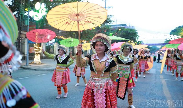 Đoàn diễn di chuyển cùng những chiếc ô nhiều màu sắc, giới thiệu nét đẹp trang phục dân tộc Mông trong không gian lễ hội.