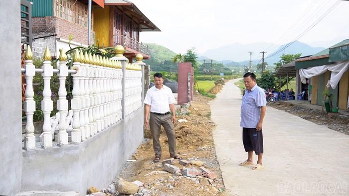 Sau khi hiến đất, gia đình ông Hoàng Ngọc Xanh (bên phải) ở thôn Ao Sen đã tự bỏ kinh phí xây dựng lại cổng, tường rào mới.