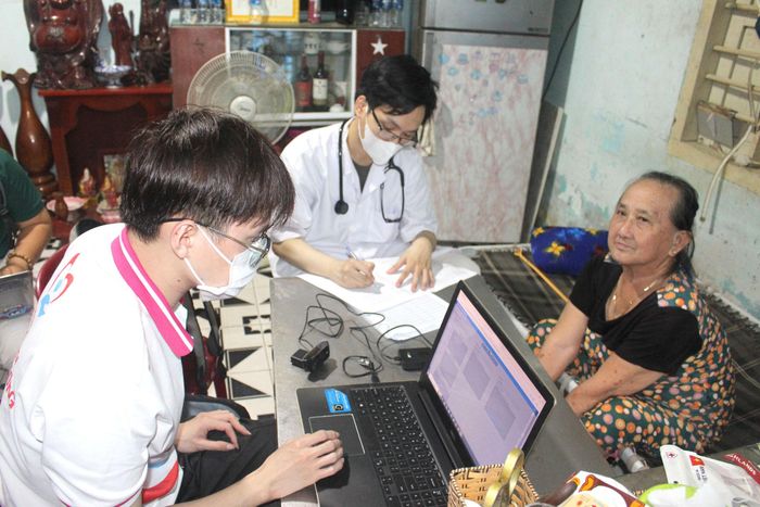 Bác sĩ Đoàn Minh Nhật (giữa), thành viên Tổ khám lưu động số 1, khám bệnh cho người dân tại nhà