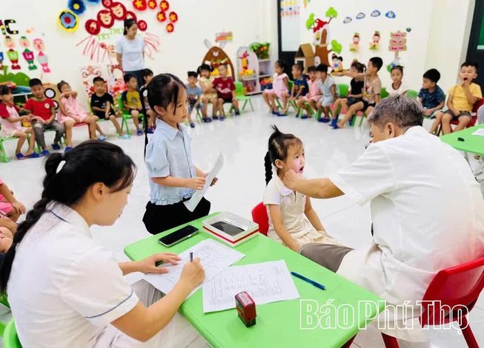 Nhân viên y tế xã Chí Đám khám sức khỏe cho học sinh trên địa bàn.
