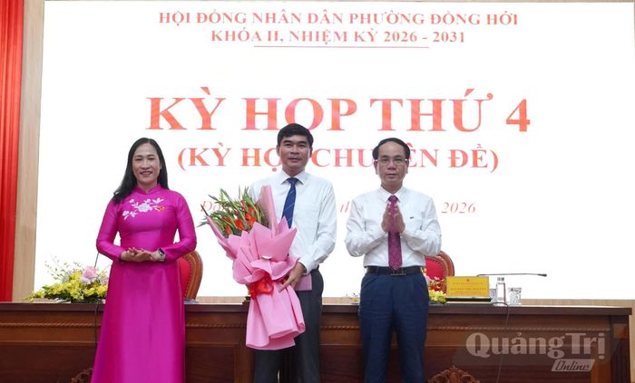 Đồng chí Phan Mạnh Hùng, Bí thư Đảng ủy phường Đồng Hới và đại diện Thường trực HĐND phường Đồng Hới tặng hoa chúc mừng đồng chí Hoàng Đức Thiện - Ảnh: H.Tr