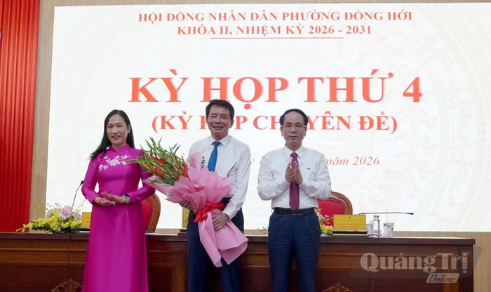 Đồng chí Phan Mạnh Hùng, Bí thư Đảng ủy phường Đồng Hới và đại diện Thường trực HĐND phường Đồng Hới tặng hoa đồng chí Hoàng Ngọc Đan chuyển công tác - Ảnh: H.Tr