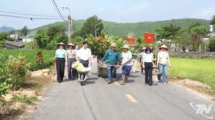 Cán bộ, hội viên phụ nữ và người dân xóm Guộc ra quân trồng hoa mẫu đơn.