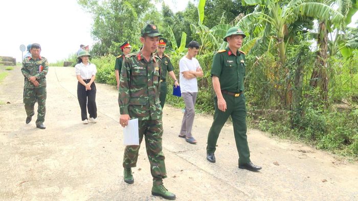 Các thành viên đoàn công tác kiểm tra địa hình, đối chiếu thông tin bản đồ để phục vụ việc xác định vị trí mộ liệt sĩ.