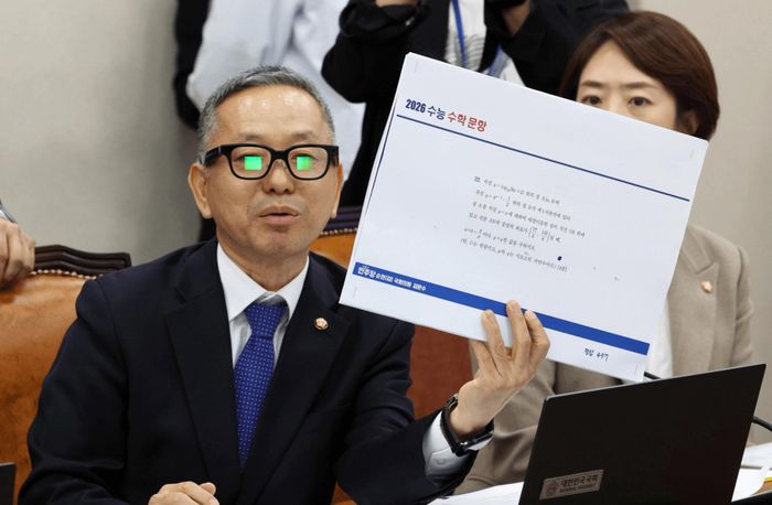 Trong phiên điều trần tại Quốc hội Hàn Quốc ngày 7/10, nghị sĩ Kim Moon-soo sử dụng kính thông minh tích hợp AI để giải một câu hỏi thuộc phần tiếng Anh của kỳ thi Suneung, chứng minh thiết bị này có thể được sử dụng để gian lận. Ảnh: Newsis