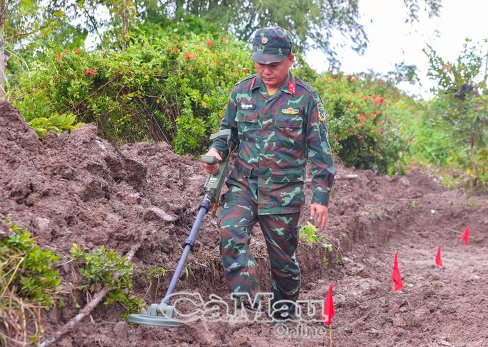 Thiếu tá Phạm Bảo Sơn, Tổ trưởng Tổ Tìm kiếm tại Xã Hồ Thị Kỷ thực hiện nhiệm vụ rà soát bom mìn.