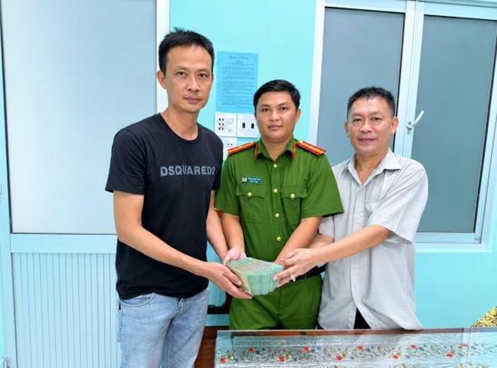 Ông Lê Hoàng Nam (bìa phải) hoàn trả số tiền hơn 367 triệu đồng nhận chuyển khoản nhầm đến ông Quách Quốc Nam (bìa trái) tại cơ quan Công an xã Vĩnh Mỹ - Ảnh: Công an tỉnh Cà Mau
