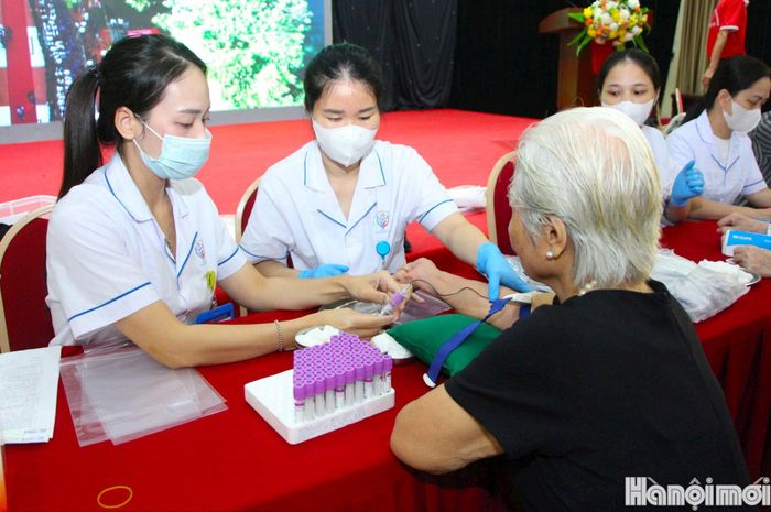 Nhân viên y tế phường Giảng Võ lấy mẫu máu thân nhân liệt sĩ. Ảnh: MH