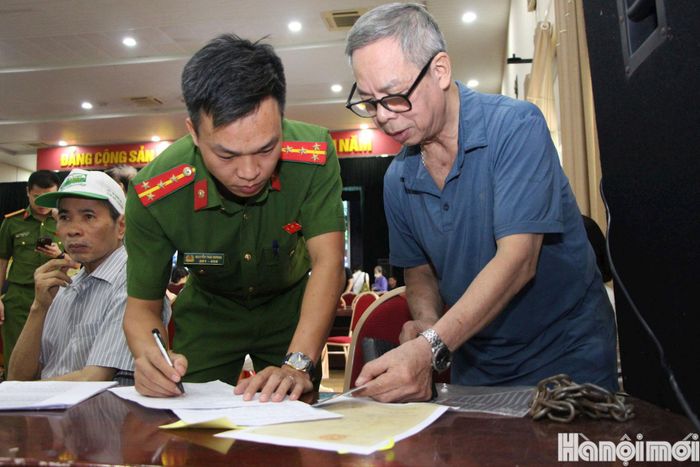 Cán bộ, chiến sĩ hướng dẫn, giúp đỡ những khó khăn, vướng mắc của người dân trong quá trình đối chiếu thông tin thân nhân liệt sĩ. Ảnh: MH