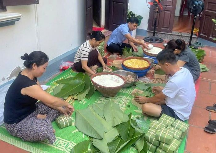Các thành viên trong gia đình quây quần gói bánh chưng tạo không khí vui tươi, góp phần gìn giữ làng nghề truyền thống giữa nhịp sống hiện đại. Ảnh: PV