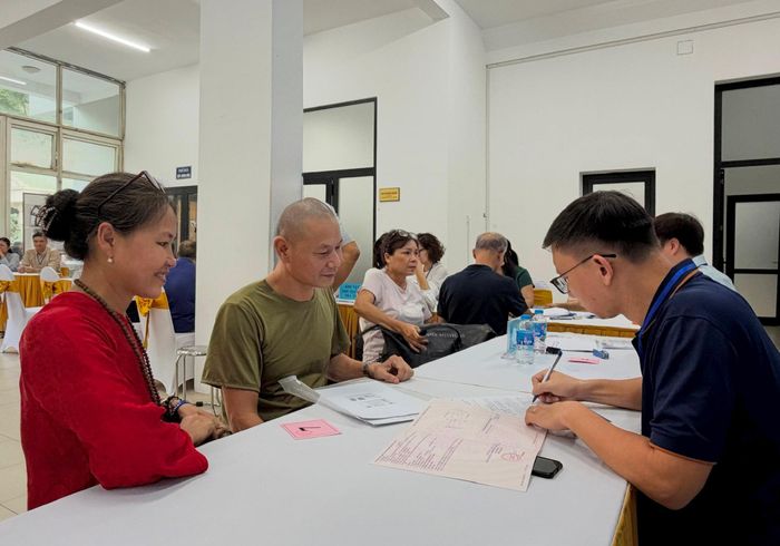 Lực lượng chức năng hỗ trợ người dân làm thủ tục nhận chi trả tiền giải phóng mặt bằng. Ảnh: Nguyên Bảo
