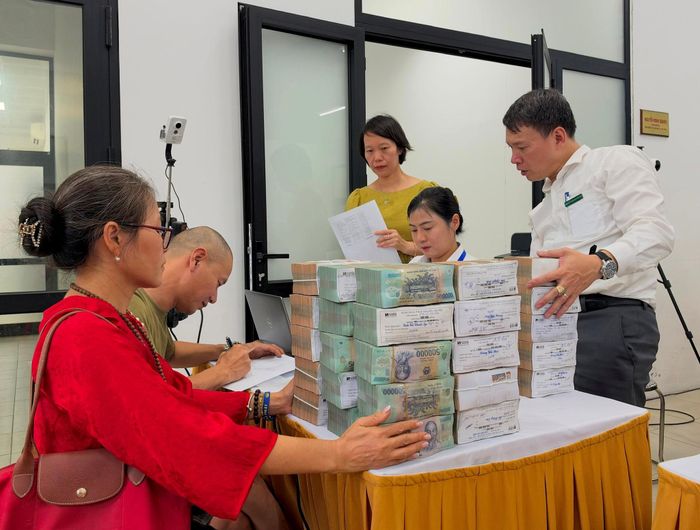 Bà Ngô Thanh Thủy nhận tiền chi trả giải phóng mặt bằng từ ngân hàng. Ảnh: Nguyên Bảo