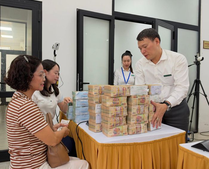 Bà Nguyễn Thu Hằng nhận tiền chi trả giải phóng mặt bằng từ ngân hàng. Ảnh: Nguyên Bảo