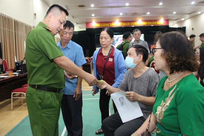 Lực lượng công an hỗ trợ người dân trong quá trình đối chiếu thông tin thân nhân liệt sĩ. Ảnh: PV