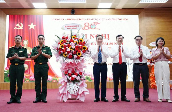 Lãnh đạo xã Ứng Hòa tặng hoa chúc mừng lực lượng vũ trang. Ảnh: Lê Quí