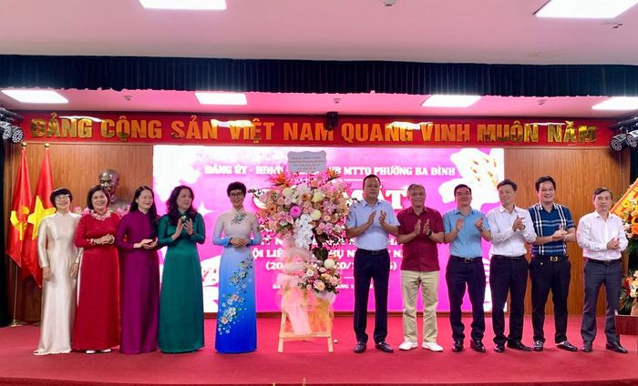 Đại diện lãnh đạo Đảng ủy, HĐND, UBND và Ủy ban MTTQ Việt Nam phường Ba Đình tặng hoa chúc mừng các nữ cán bộ chủ chốt. Ảnh: PV