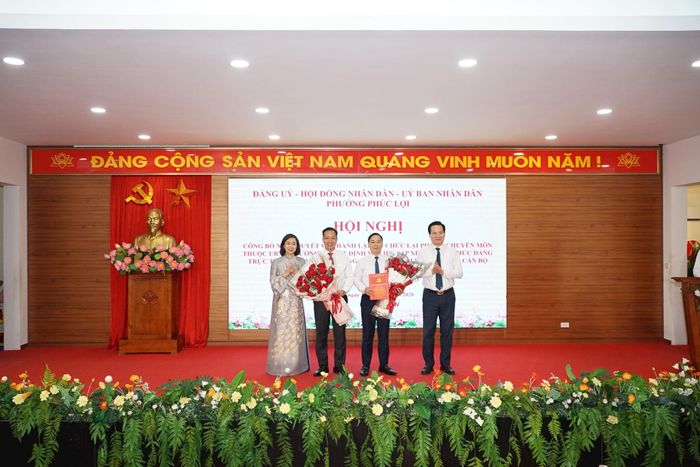 Đại diện lãnh đạo Đảng ủy - HĐND - UBND phường trao quyết định và tặng hoa chúc mừng các đồng chí Bí thư Đảng uỷ các cơ quan Đảng và UBND phường. Ảnh: Bình Nguyên