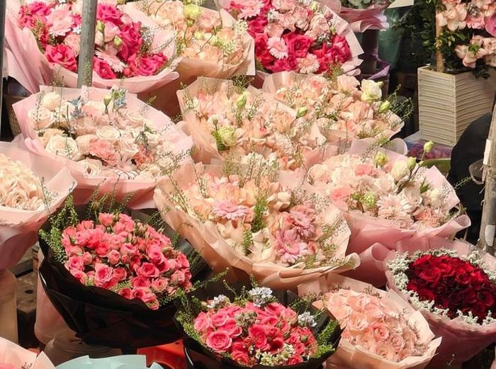 Các quầy hàng tại chợ Quảng An bày bán nhiều loại hoa với mức giá khác nhau, từ khoảng 100.000 đồng đến gần 300.000 đồng mỗi bó hoặc cành, tùy loại.