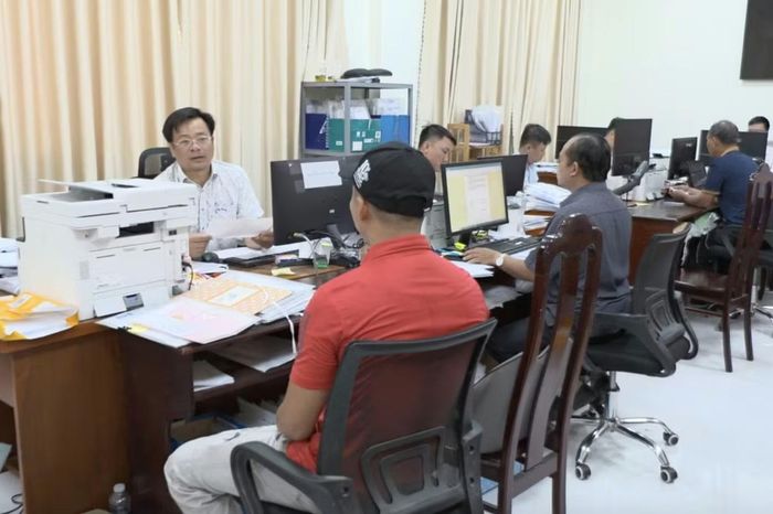 Cán bộ Văn phòng Đăng ký đất đai hướng dẫn người dân cấp sổ đỏ.
