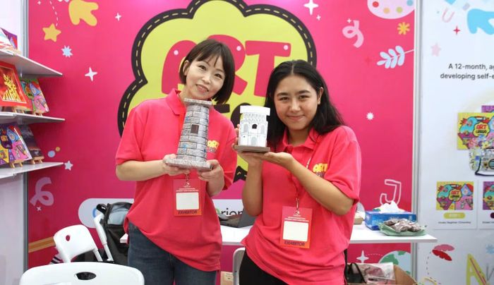 Đại diện thương hiệu Art Crego giới thiệu các mô hình giấy 3D (Đấu trường Colosseum, tháp nghiêng) thuộc chương trình mỹ thuật tích hợp ngôn ngữ và lịch sử. (Ảnh: Bảo Ngân)