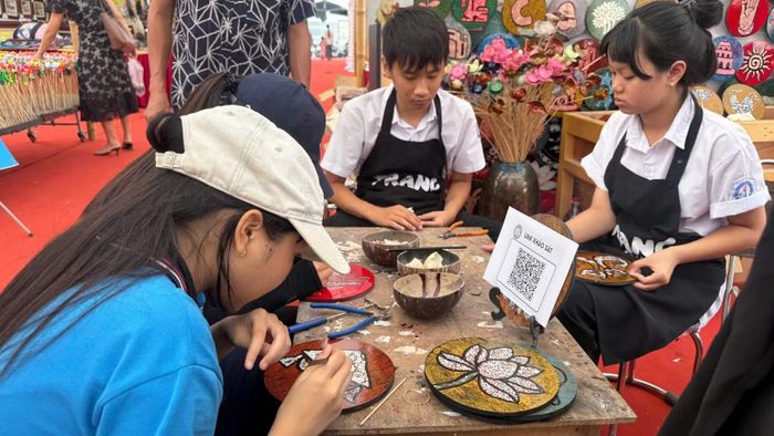 Các em học sinh Trường trung học cơ sở Phú Xuyên trải nghiệm làm tranh sơn mài tại chương trình. (Ảnh: DIỆU THƯƠNG)