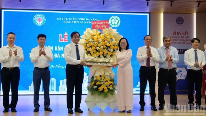 Giám đốc Sở Y tế Đà Nẵng Trần Thanh Thủy trao quà lưu niệm là mô hình cầu Rồng Đà Nẵng cảm ơn Ban giám đốc Bệnh viện Bạch Mai. (Ảnh: ANH ĐÀO)