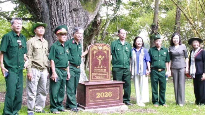 Các đại biểu chụp ảnh lưu niệm cùng cây di sản Việt Nam tại Di tích Tà Thiết. (Ảnh: NS)