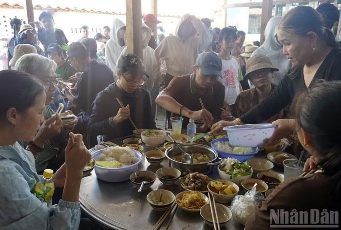 Một người dân Long Sơn đang phục vụ cơm, thức ăn miễn phí cho du khách từ nơi khác đến. (Ảnh: LÊ ĐÌNH THÌN)