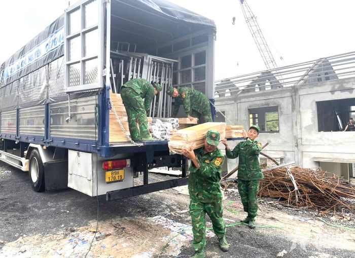 Cán bộ, chiến sĩ Đồn Biên phòng Cửa khẩu Săm Pun vận chuyển vật liệu xây dựng, góp sức hoàn thiện cơ sở vật chất Trường Phổ thông nội trú liên cấp Tiểu học và Trung học cơ sở Sơn Vĩ. 