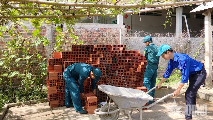 Dân quân xã Mỹ Đức Tây, tỉnh Đồng Tháp vận chuyển vật liệu xây dựng giúp các gia đình xây dựng nhà.