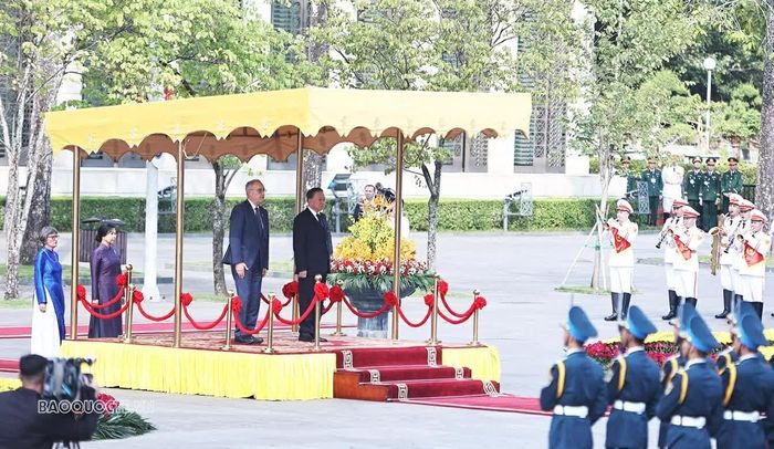 Trong tiếng nhạc chào mừng, hai lãnh đạo đi dọc thảm đỏ, bước lên bục danh dự. Quân nhạc cử Quốc thiều hai nước. (Ảnh: Thành Long)