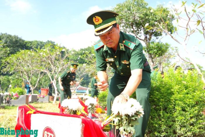 Thiếu tướng Trần Ngọc Hữu thắp hương tại các phần mộ trong nghĩa trang. Ảnh: Lê Khoa