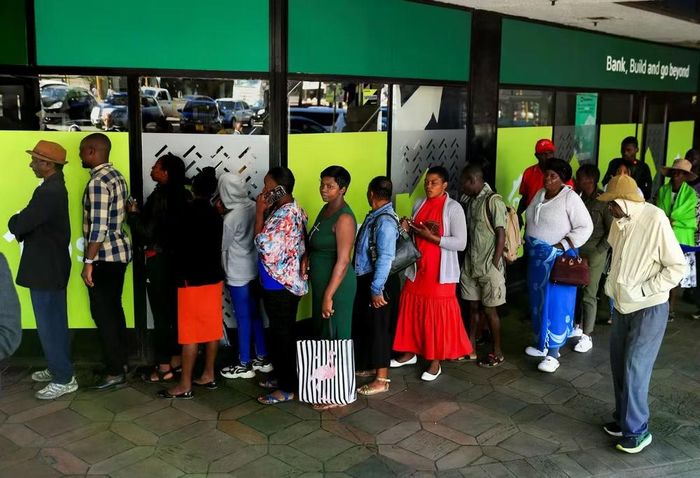 Người dân xếp hàng rút tiền tệ mới tại một ngân hàng địa phương ở Harare, Zimbabwe. Ảnh: SCMP.