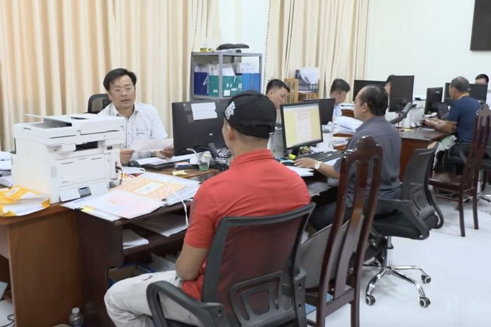 Cán bộ Văn phòng Đăng ký đất đai hướng dẫn người dân cấp sổ đỏ.