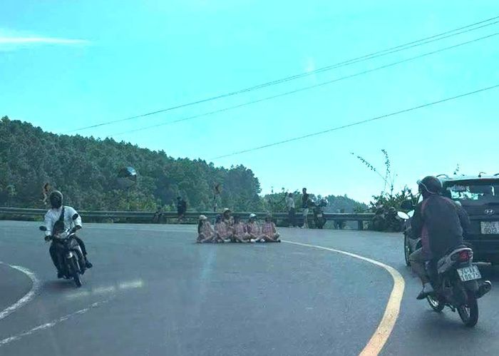Hình ảnh nhóm 6 phụ nữ ngồi giữa khúc cua ở đèo Hải Vân để chụp ảnh. Ảnh: T.T
