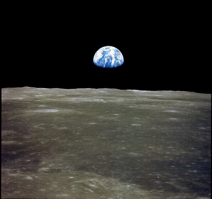 Hình ảnh Trái Đất mọc (Earthrise) khi tàu Apollo 11 di chuyển vòng qua rìa Mặt Trăng, để lộ một Trái Đất đơn độc lơ lửng giữa vực thẳm đen tối của không gian. Nguồn: NASA