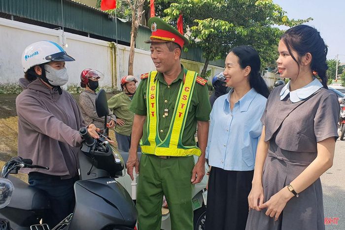 Lực lượng chức năng và giáo viên Trường Tiểu học Can Lộc – Trường chính, xã Can Lộc nhắc nhở phụ huynh đảm bảo an toàn giao thông trước cổng trường.