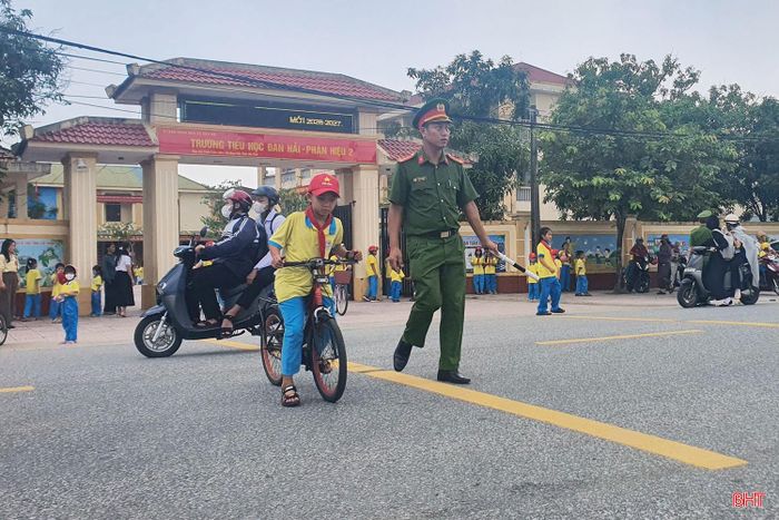 Lực lượng Công an xã Đan Hải đảm bảo an toàn giao thông cho học sinh khi qua đường.