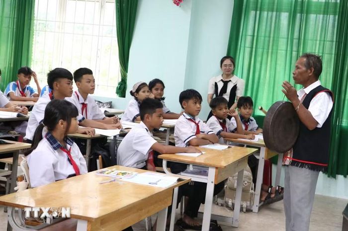 Nghệ nhân Ưu tú Đinh Thanh Sơn truyền dạy cách đánh chiêng cho học sinh Trường Phổ thông dân tộc bán trú Tiểu học và Trung học cơ sở Đinh Thanh Kháng. (Ảnh: Đinh Hương/TTXVN)