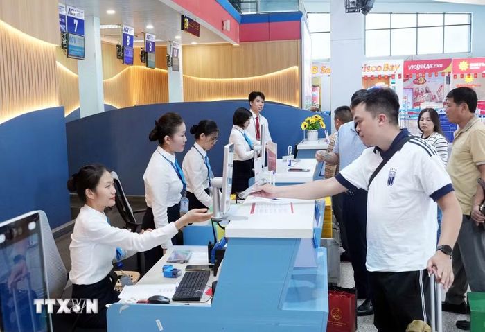 Nhân viên hàng không làm thủ tục cho hành khách tại quầy làm thủ tục chuyến bay chặng Đồng Hới-Cam Ranh ở Cảng hàng không Đồng Hới, Quảng Trị. (Ảnh: Tá Chuyên/TTXVN)