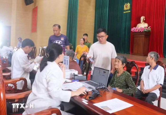 Cán bộ kỹ thuật đối chiếu thông tin và tiến hành lấy mẫu sinh phẩm ADN thân nhân liệt sỹ chưa xác định danh tính tại điểm thu nhận mẫu Công an phường Long Xuyên, tỉnh An Giang. (Ảnh: Công Mạo/TTXVN)