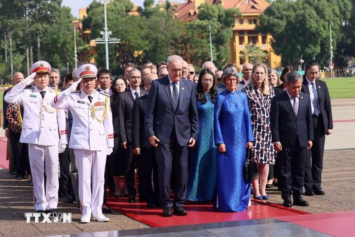 Tổng thống Guy Parmelin và Phu nhân Caroline Parmelin cùng Đoàn đại biểu cấp cao Thụy Sĩ kính cẩn tưởng niệm Chủ tịch Hồ Chí Minh. (Ảnh: An Đăng/TTXVN)