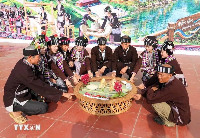 Thầy cùng các chủ trâu ngồi quanh bàn lễ và cùng đặt ngón tay lên bàn lễ để cúng xin thần linh cho trâu trả hồn chủ. (Ảnh: Quý Trung/TTXVN)