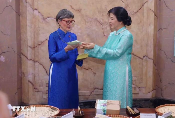 Phu nhân Ngô Phương Ly trao tặng Phu nhân Caroline Parmelin chiếc gối thảo dược do chính tay mình thực hiện, thể hiện tình cảm chân thành và sự trân trọng dành cho vị khách quý. (Ảnh: Phạm Kiên/TTXVN)