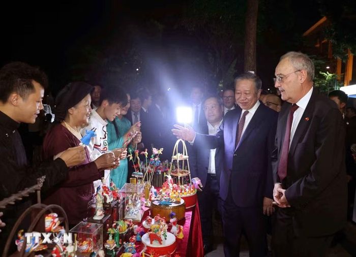 Tổng Bí thư, Chủ tịch nước Tô Lâm giới thiệu với Tổng thống Thụy Sĩ Guy Parmelin về nghệ thuật tò he - nét văn hóa dân gian độc đáo trên phố đi bộ. (Ảnh: Thống Nhất/TTXVN)