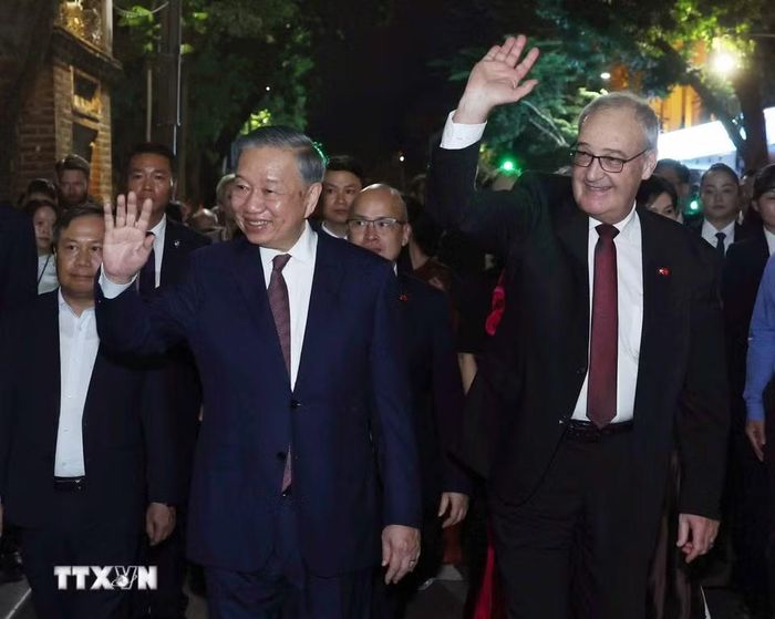 Tổng Bí thư, Chủ tịch nước Tô Lâm và Tổng thống Thụy Sĩ Guy Parmelin vẫy chào du khách và nhân dân Thủ đô khi đi dạo phố đi bộ hồ Hoàn Kiếm. (Ảnh: Thống Nhất/TTXVN) ​