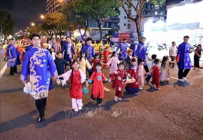 Trẻ em và người lớn cùng tham gia đoàn diễu hành áo dài, tạo nên không khí gần gũi, sinh động trên đường phố Đà Nẵng.