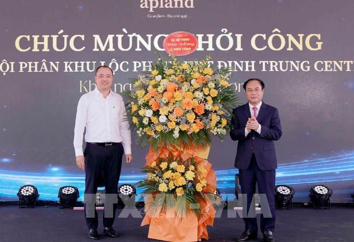 Thứ trưởng Bộ Xây dựng Nguyễn Văn Sinh tặng hoa chúc mừng chủ đầu tư tại lễ khởi công Dự án Nhà ở xã hội phân khu Lộc Phát. Ảnh: Hoàng Hùng - TTXVN 