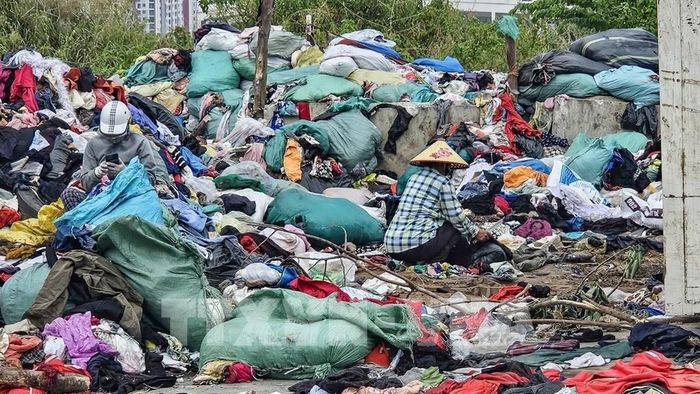 Quần áo cũ chất thành đống lớn tại khu đất thuộc dự án đường nối Phạm Hùng – Lê Đức Thọ, phường Từ Liêm (Hà Nội). Ảnh: Trung Nguyên - TTXVN.